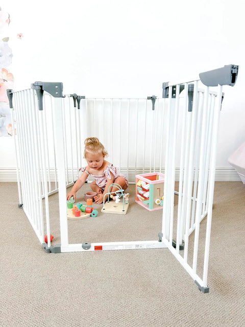 Toddler playing inside Royale Converta 3 In 1 Play Yard And 151 Inch Wide Baby Gate, 6 configurable panels with toys.