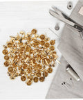 Versatile Craft Kit 100 Pcs Round Mushroom Brads And Mini Paper Fasteners in a pile on a white wooden surface