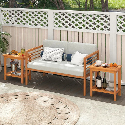 Acacia Wood Outdoor Side Table With Slatted Top And Two Tier Storage Shelf For Backyard Poolside Patio Or Indoor Use Built To Last In Natural Finish No Fuss Durability beside a sofa outdoors