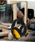 Lock Down Every Distraction Heavy Duty Noise Reduction Earmuffs on a workbench, featuring black and yellow design, perfect for industrial hearing protection.