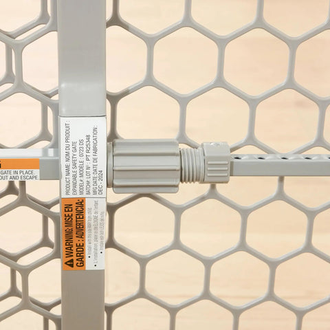 Close-up of expandable mesh panel and pressure knob on Expandable Baby Gate 28 To 42 Inch Wide For Doorways And Bottom Of Stairs Pressure Mounted Safety Gate For Babies Toddlers And Pets Tested And Safe For 30 Years American Designed And Owned.
