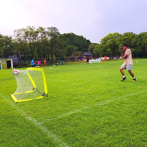 Go To Portable Backyard Soccer Goal Kit With 2 By 2.6 Ft Net in use on a green field with player kicking a ball into the net