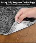 Hand lifting rug corner showing 8 Pack Non Slip Rug Grippers For Hardwood Floors Washable And Reusable Carpet Tape on wood floor