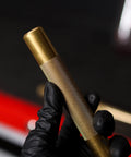 Close-up of Two Piece Brass Drift Pin Punch Set, non marring mechanic chisel, held by gloved hand, for auto repair.