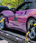 Sports car secured with Heavy Duty Car Tie Down Straps With Flat Hooks 10000 Lb Break Strength 4 Pack Tire Ratchet Straps For Trailers Trucks And UTVs 10Ft Lasso Straps Fit All Size Tires Smooth D Ring Hooks For Easy Mounts On Side Rails on a flatbed trailer.