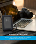 G Drive ArmorATD 5TB Rugged Portable External Hard Drive USB C 5Gbps USB 3.2 Gen 1 next to laptop and camera outdoors