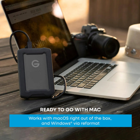G Drive ArmorATD 5TB Rugged Portable External Hard Drive USB C 5Gbps USB 3.2 Gen 1 next to laptop and camera outdoors