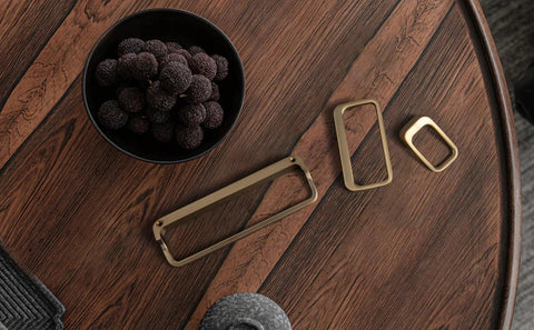 Champagne Bronze Cabinet Pulls With Center Hole 5 Inch Length Modern Zinc Finger Handles for drawers and cupboards on a wooden surface