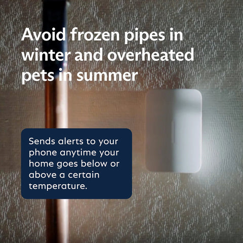 SimpliSafe temperature sensor mounted on textured wall beside a copper pipe, white plastic with temperature alert overlay