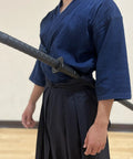 Person wearing a 39 Inch Polypropylene Martial Arts Training Sword With Black Saya Scabbard, durable lightweight practice blade.
