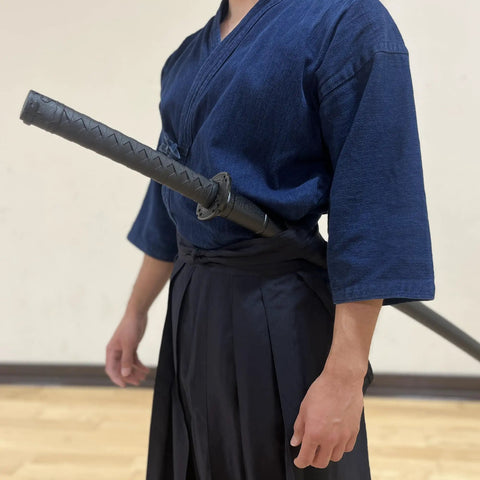 Person wearing a 39 Inch Polypropylene Martial Arts Training Sword With Black Saya Scabbard, durable lightweight practice blade.