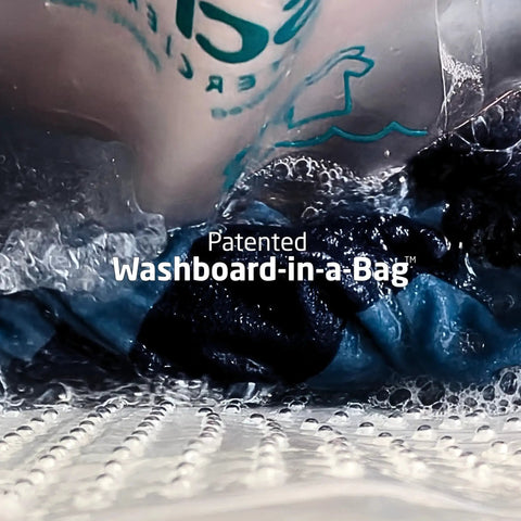 Pocket Sized Portable Travel Wash Bag Featuring Patented Washboard Design in use with bubbles on dark clothes.