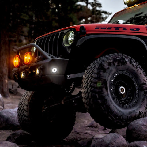 Off-road vehicle with Cyclone V2 LED 5W Flood Beam Light With Clear Lens, ideal for rock crawling, evening setting.