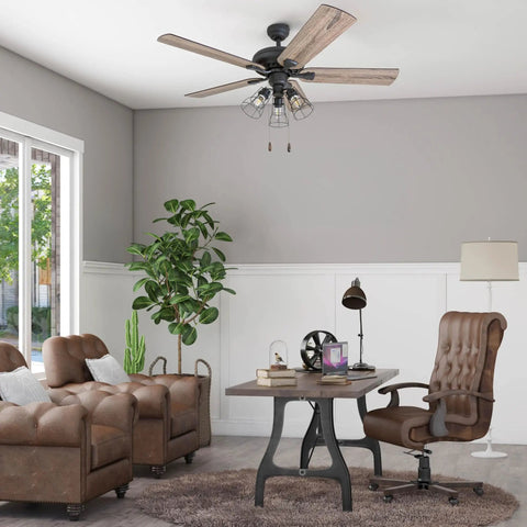52-Inch Industrial Style LED Ceiling Fan With Light Kit, Bronze Finish, in living room setup with Edison style cage lights.