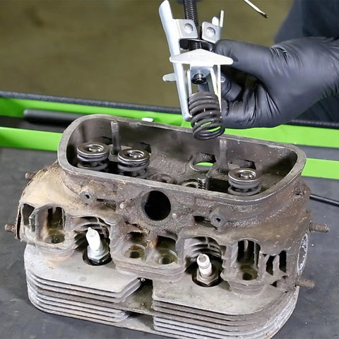 Overhead Valve Spring Compressor Tool For Cars And Trucks in use on engine head removing valve spring.