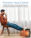 Cozy Up With MyHeat Max Portable Ceramic Space Heater For Indoor Use next to a seated man in a modern home setting