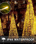 Outdoor display of Indoor String Lights With Remote 33ft 100 LED Warm White Twinkle Fairy Lights illuminating conical trees.