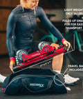 Woman packing Omnium Over-Drive Lightweight Portable Bike Trainer with Travel Bag, Adjustable Wheelbase and Fork Mount, Red.