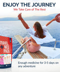 Front view of red travel medicine kit box (78-piece TSA-friendly) by Amazon beside traveler on a boat deck