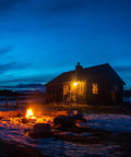 Log cabin illuminated at dusk with snow, showcasing ambience with LED Bug Light A19 Replaces 100W Incandescent, Amber Yellow Spectrum.