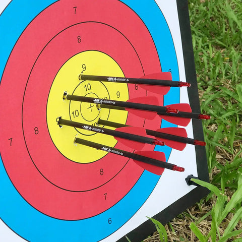 Four 7.5 inch R9 crossbow bolts carbon arrows with 2 inch red vanes on target
