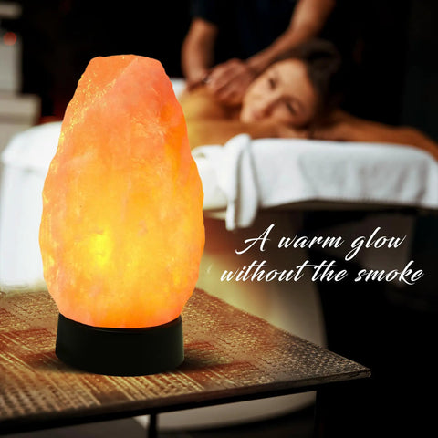 Multicolor USB LED Salt Lamp With Plastic Base For Home Office Dorm Decor, Hand Carved Salt Lamp For Relaxation Ambience Air Purification And Chill Vibes glowing beside a massage table