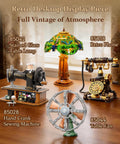Retro Desktop Display Piece featuring a Retro Buildable Desk Fan Model For Adults Dope Green Display Piece With Motorized Oscillation Realistic Grille Weighted Base Bronze Blades Vintage Inspired Decor alongside vintage lamp, phone, and sewing machine on a wooden table.