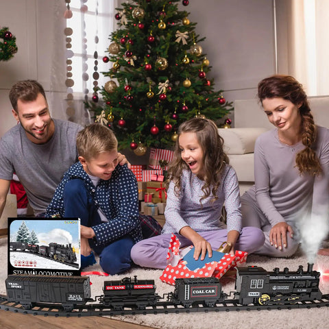 Family playing with Electric Train Set For Kids With Steam Locomotive And Cargo Cars Tracks And Railway Kit near Christmas tree
