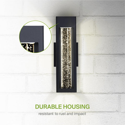 Lit Bubble Glass Tube Wall Sconce With Crystal Look, 12W LED waterproof light on white brick wall highlighting rust resistance.