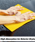 Hands using Ultra Absorbent Microfiber Cleaning Cloths 100 Pack 12x12 Inches All Purpose Towels for drying car surface.