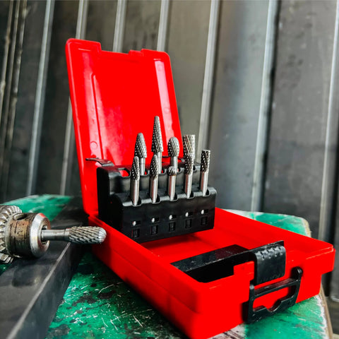 Front view of a 10-piece tungsten carbide burr set with 1/4" shanks in a red plastic case.