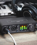 USB C Audio Interface With 2 Preamps And Hardware Monitoring 2 In 2 Out 24Bit 192kHz Recording Compatible With Mac Windows And iOS Black Studio Rig with headphones and keyboard.