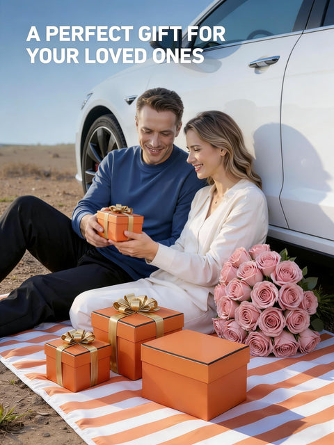 Couple sitting by a white car, exchanging gift boxes on a picnic blanket, roses beside them.
