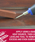 Quick Fill Burn In Stick Wood Filler In True Brown Shade being applied with a heat gun on hardwood surface for repairs.