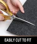 Person cutting Oil Spill Mat For Garage Floor 7.4 By 8.4 Feet Premium Absorbent Pad With Waterproof Rubber Backing with scissors