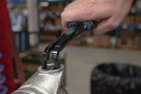 Close-up of 75 Degree U Joint Snap Ring Pliers Pro Grade for automotive use installing a retaining ring on metal.