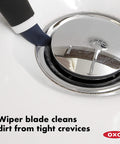 Blue Good Grips Deep Clean Brush Set with small brush wiper blade cleaning chrome sink fixture, non-slip comfort grips.