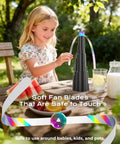Girl using Tabletop Fly Fans With USB Type C Rechargeable Battery And Colorful LED Light Show, Foldable Soft Holographic Blades, outdoors.