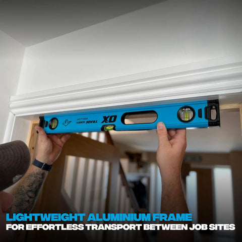 Person using Pro Grade 2 Foot Aluminum Level Box Beam With Magnified Vials Shock Absorbing End Caps on door frame.