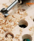 KENDO alloy-steel Forstner drill bit, close-up view cutting wood with shavings on a plywood board