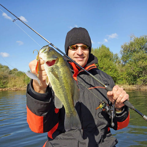 Angler holding bass with 40 Piece Hard Metal Spinner Lure Kit With Tackle Boxes For Bass Pike Walleye Trout Salmon Colorful Spoon Baits