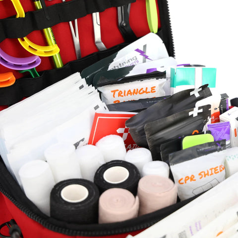 Lightning X mid-sized EMT bag, red, opened to show first-aid supplies (gauze rolls, tapes, bandages)