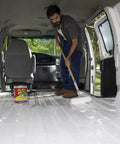 Man applying Liquid Rubber Coating Sealant For Waterproof, Flexible Protection On Roofs, Basements, RVs with brush inside van