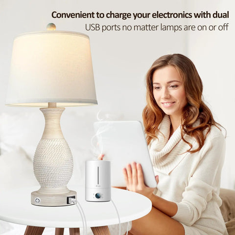 Set Of 2 Farmhouse Table Lamps With USB C And USB A Fast Charging Ports, 26 Inch Tall, 3 Way Dimmable White Fabric Shade, Cozy Living Room Or Bedroom Lighting Vibe, Sturdy Polyresin Base next to woman using tablet
