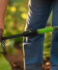 Handy Tiny Garden Rake With Telescoping Handle 27 To 39 Inches Non Slip Grip used in vegetable garden by person wearing gloves