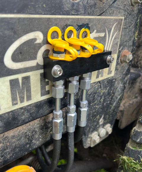 Close-up of installed yellow grease fitting caps on machinery showing the integrated collar; Grease Fitting Caps 50 Count Yellow Must Have For Any Mechanic Fits All Standard SAE And Metric Fittings With Integrated Collar That Keeps Cap Attached For Quick Maintenance And Keeps Dirt Out And Prolongs Fitting Life.