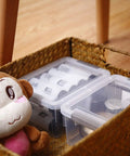 Clear White 10 Pack 1.3 Qt Small Storage Bins With Lids in a woven basket, stackable plastic containers for organizing, beside a plush toy