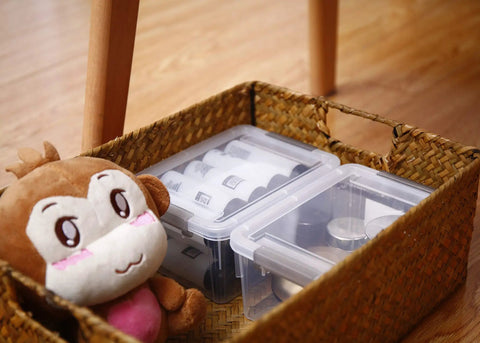 Clear White 10 Pack 1.3 Qt Small Storage Bins With Lids in a woven basket, stackable plastic containers for organizing, beside a plush toy