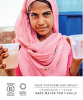 A person in a pink scarf holding two cups of water, standing in front of a blue container. Text: Safe water for children impact statement.