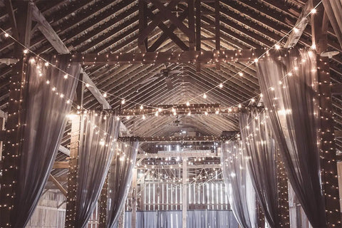 Rustic barn interior adorned with 100 Feet Outdoor G40 Globe String Lights Waterproof IP44 Dope Patio Lighting for weddings and events.